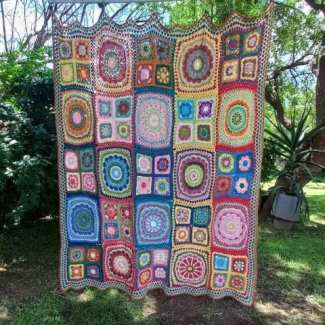 open blanket hanging from tree crochet flower squares