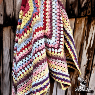 Rainbow scrap yarn crochet baby blanket full of vibrant colors and textures