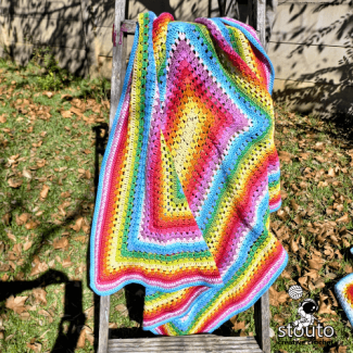 Soft rainbow striped crochet baby afghan with smooth texture