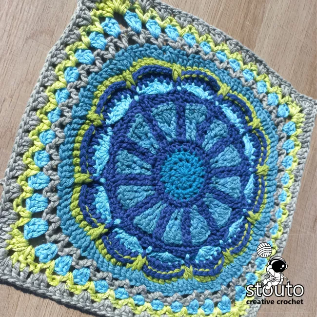 Close-up of the TMBJGF Flower Granny Square showing raised flower petals and textured crochet stitches.
